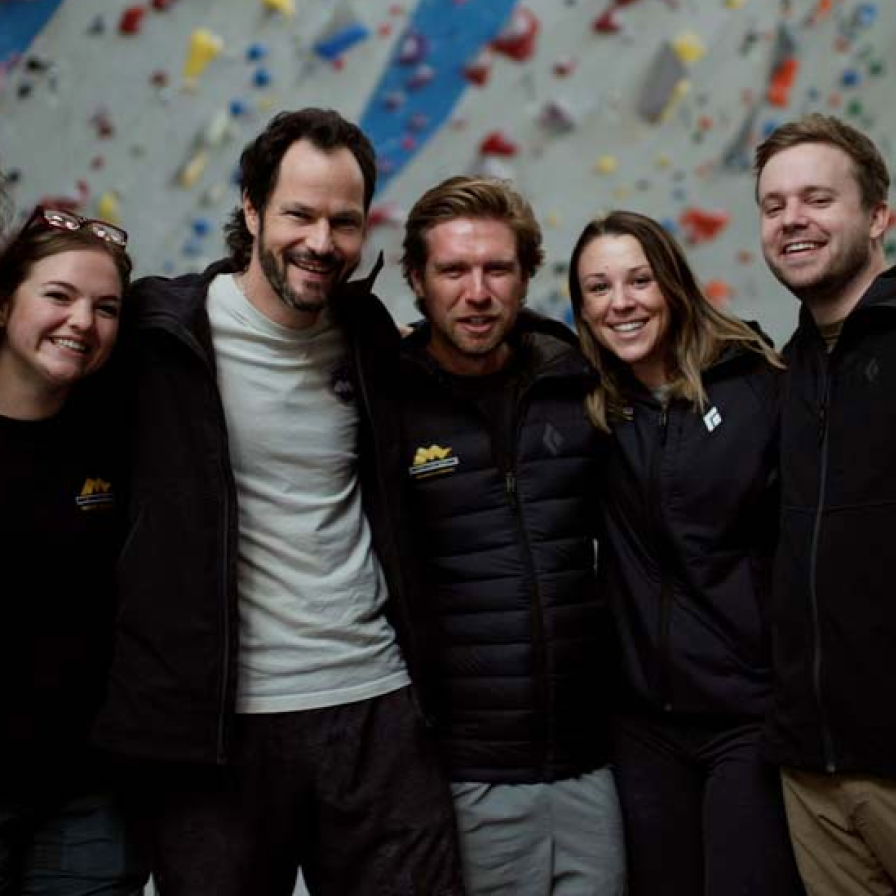 Momentum Climbing Gym staff in front of a climbing wall