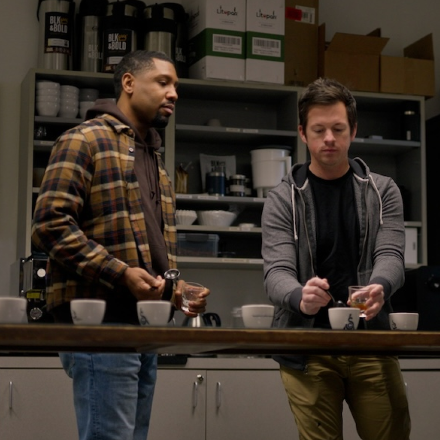 BLK & Bold staff members behind a row of cups