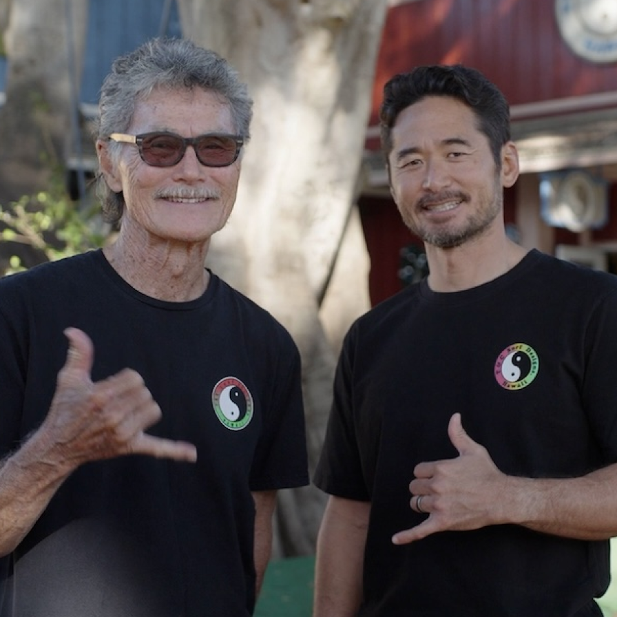 T&C Surf staff members doing the shaka sign