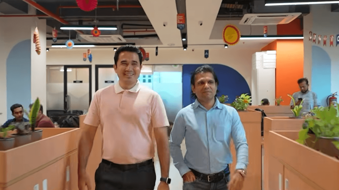 Two men walking through the LenDenClub office