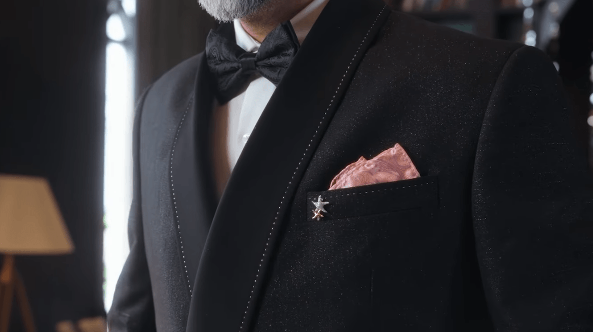 A close-up of a man wearing a black Raymond tuxedo.