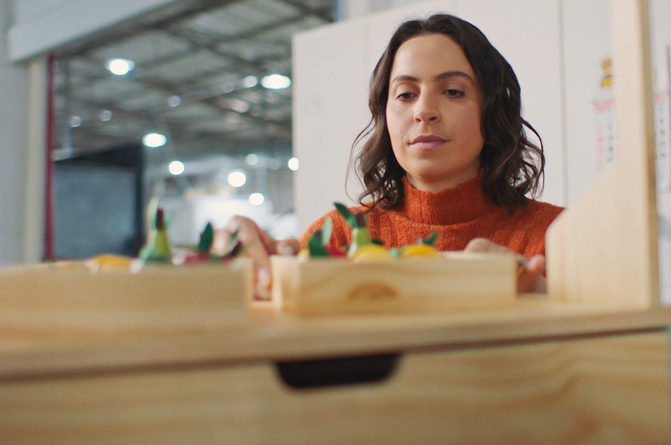 Uma mulher finalizando a organização de um brinquedo de madeira. 