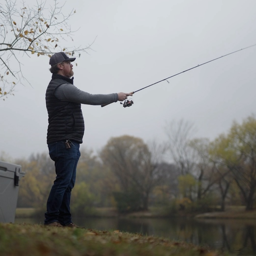 A man fishing on a lake with a Bison Coolers