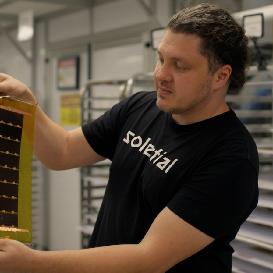 Solestial staff member examines equipment in a workspace