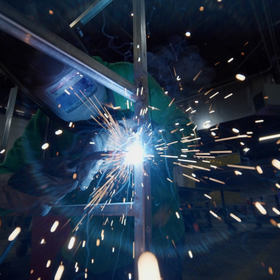 Ace Sign Co member welding a metal structure,	