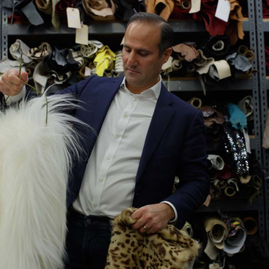 Mood Fabrics staff member holding fabrics