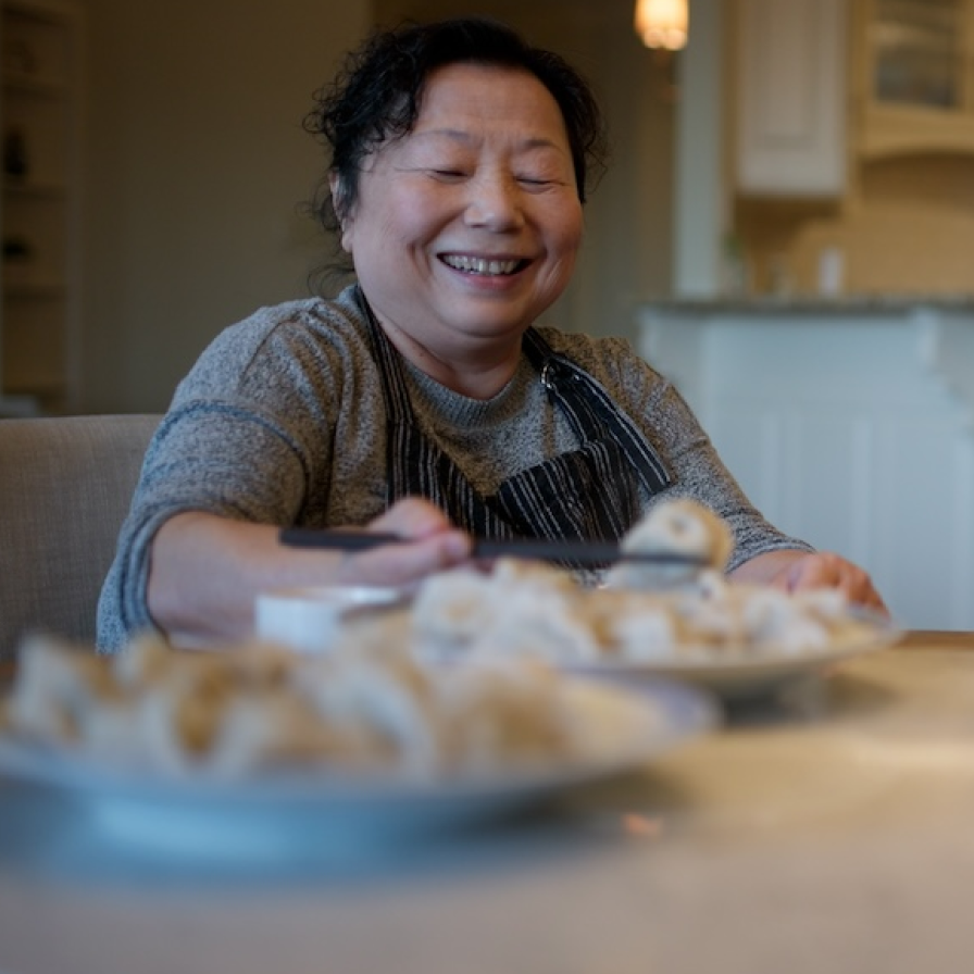 Three Fold Noodles + Dumpling Co staff member with plates of dumplings