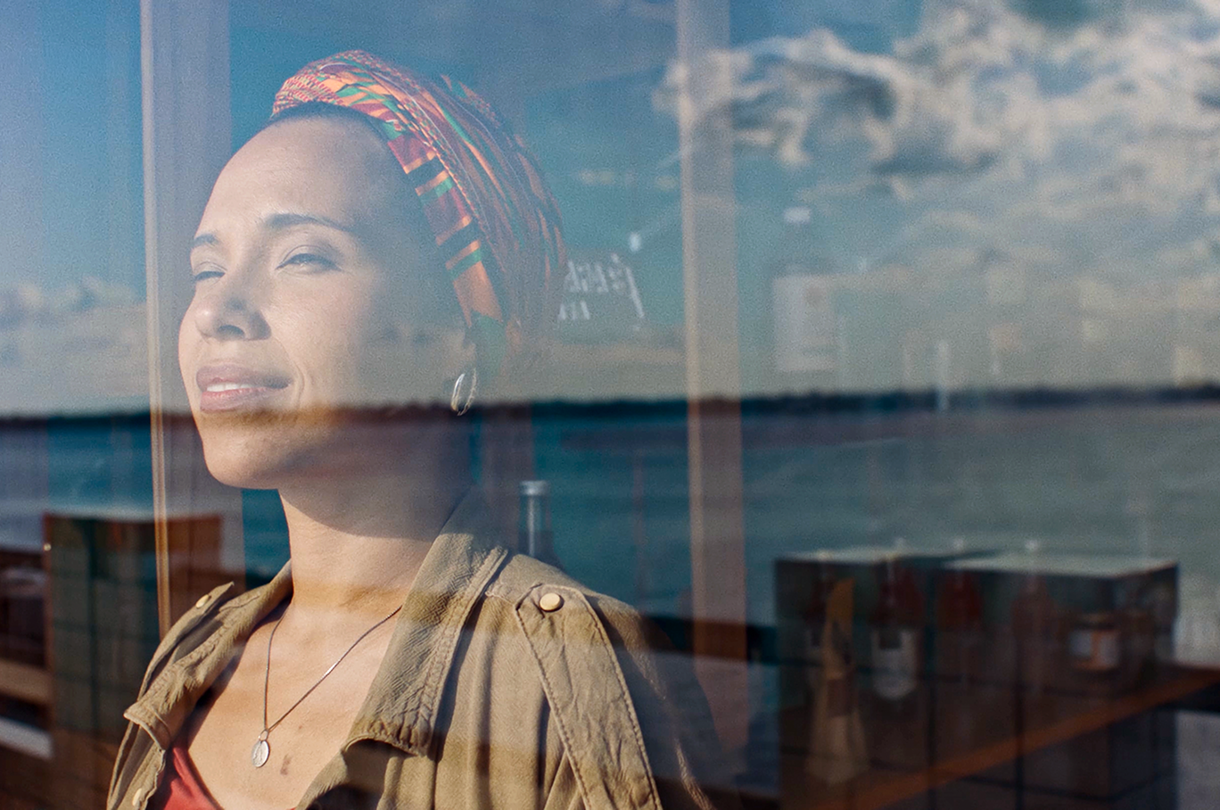 Uma mulher contemplando o rio em um horizonte.